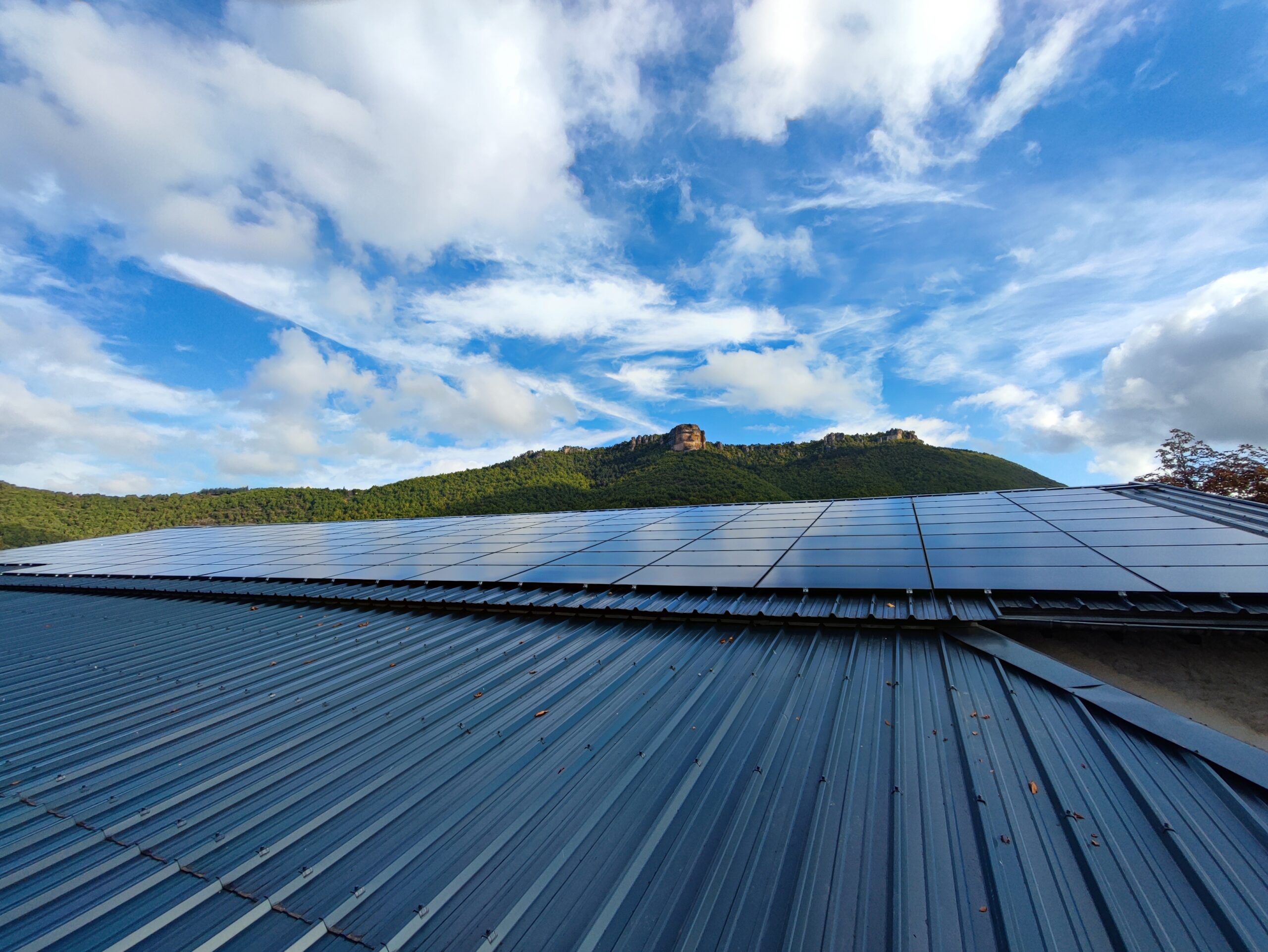 Toiture photovoltaïque avec en arrière plan un mont et le ciel